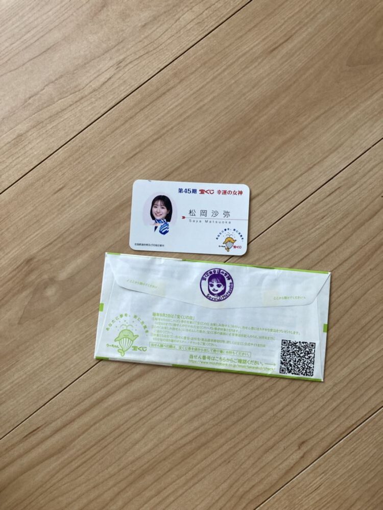 「写真の説明」 サマージャンボ宝くじのパッケージに幸運の女神のスタンプが押されてる写真