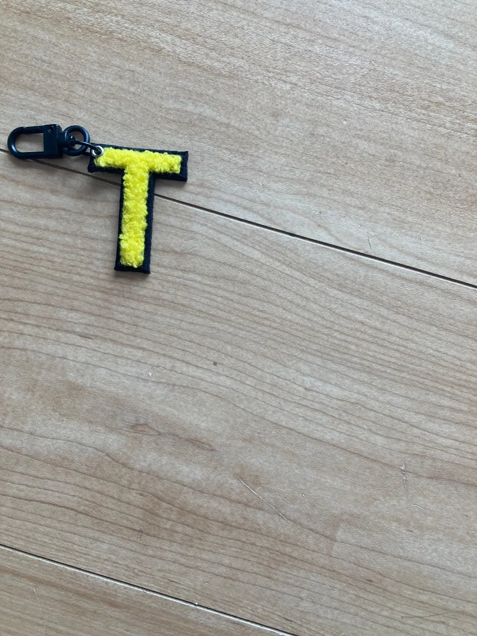 「写真の説明」黄色のアルファベットの「T」のキーホルダー